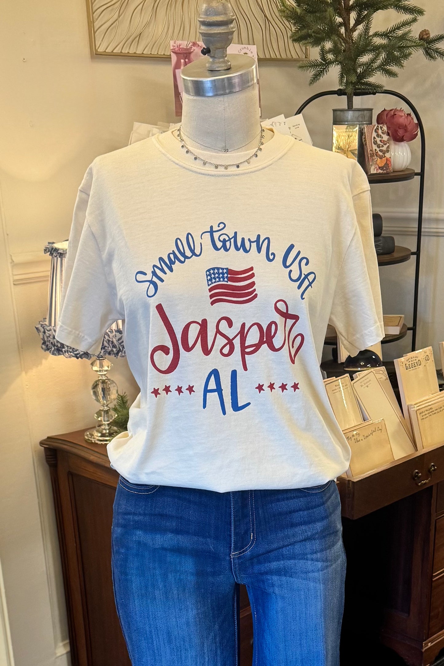 Mannequin wearing a white t-shirt with 'Small Town USA Jasper AL' text and American flag design.