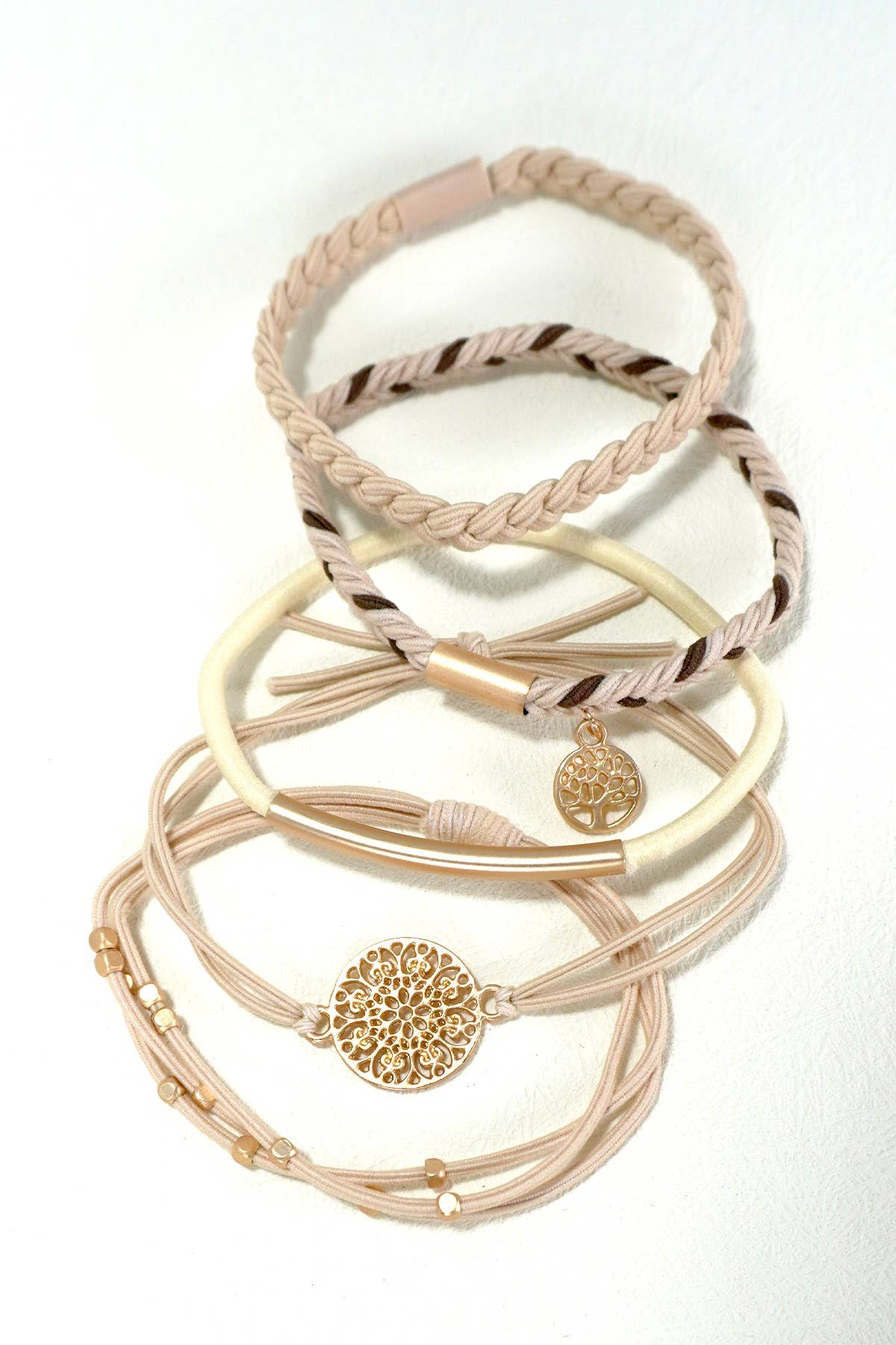 Stack of gold and beige bracelets on a white background