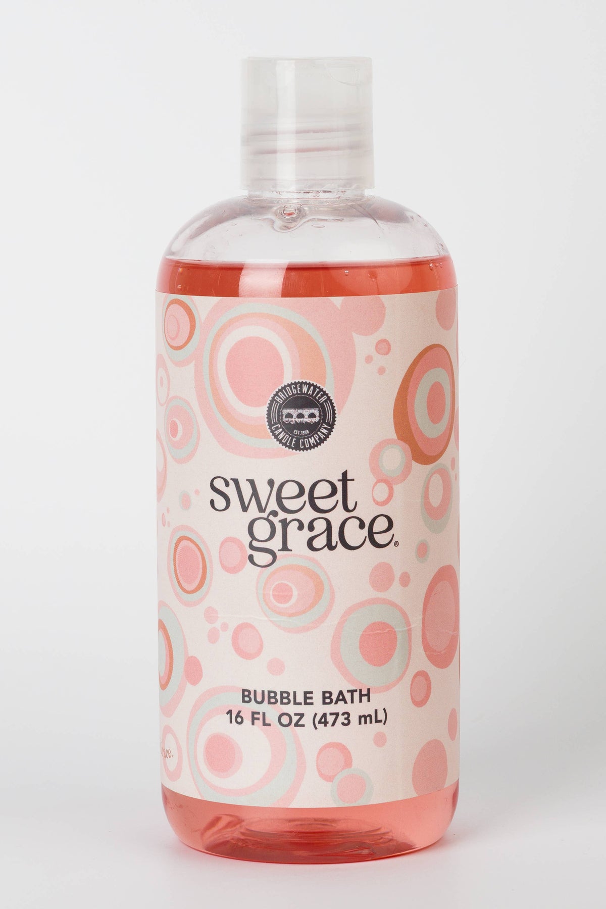 A 16 fl oz bottle of Sweet Grace Bubble Bath with pink liquid inside, featuring a white label with pink and orange concentric circles and a clear cap, set against a plain white background.