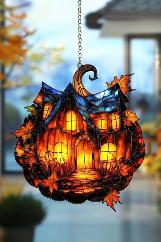 Decorative stained glass look  pumpkin with autumn leaves hanging outdoors.