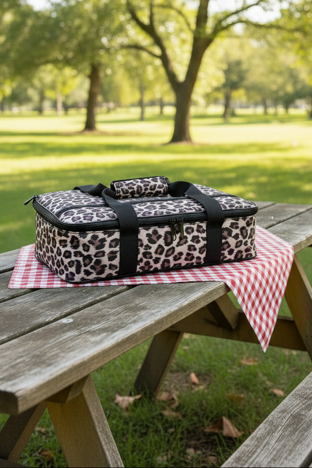 Leopard print travel bag with black straps on a white background