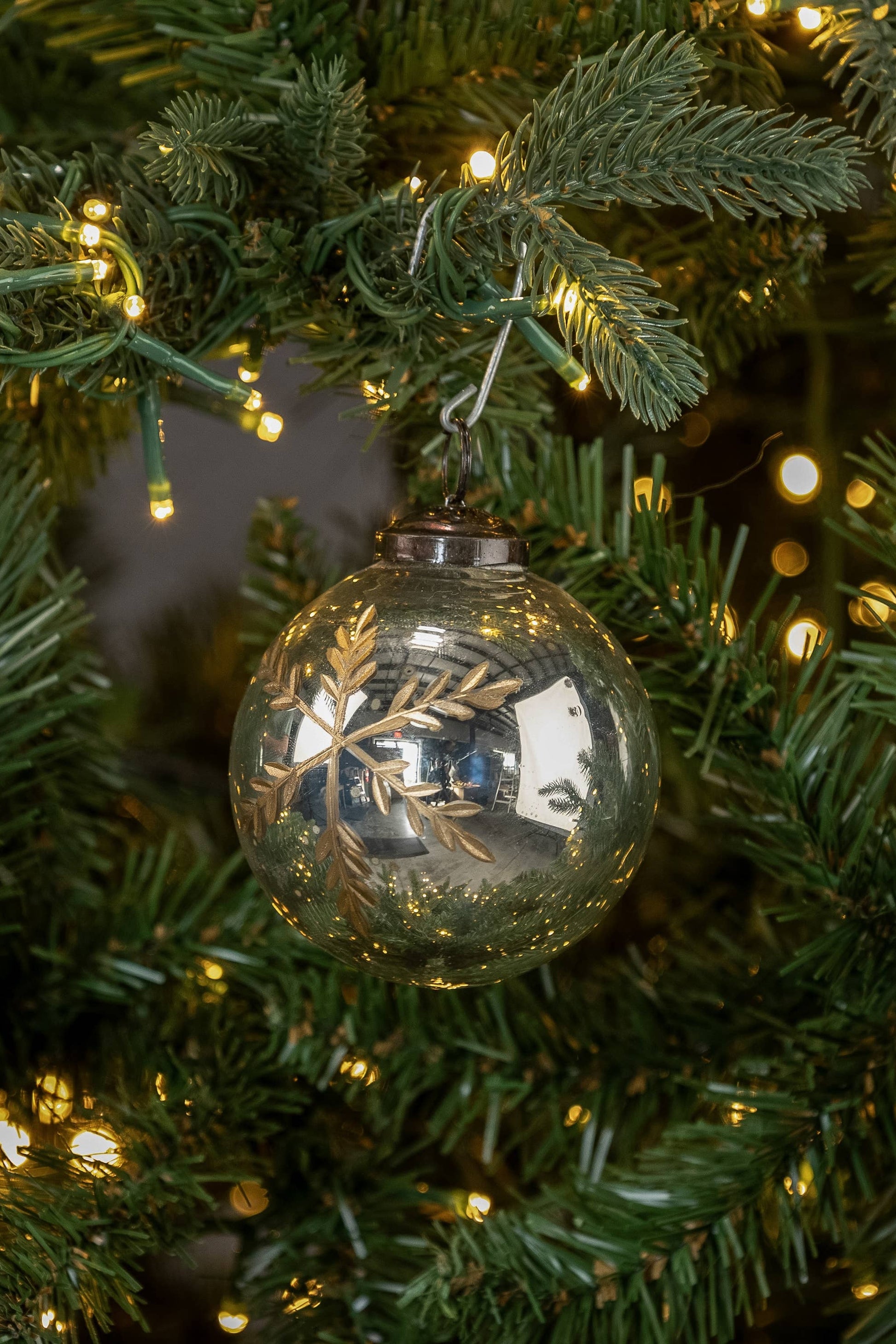 Decorative glass ornament on a Christmas tree with lights