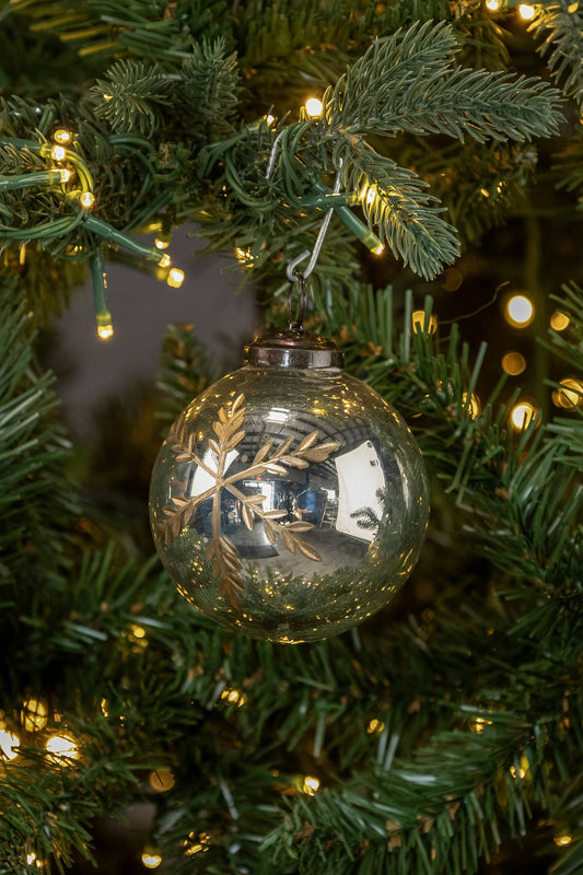 Decorative glass ornament on a Christmas tree with lights