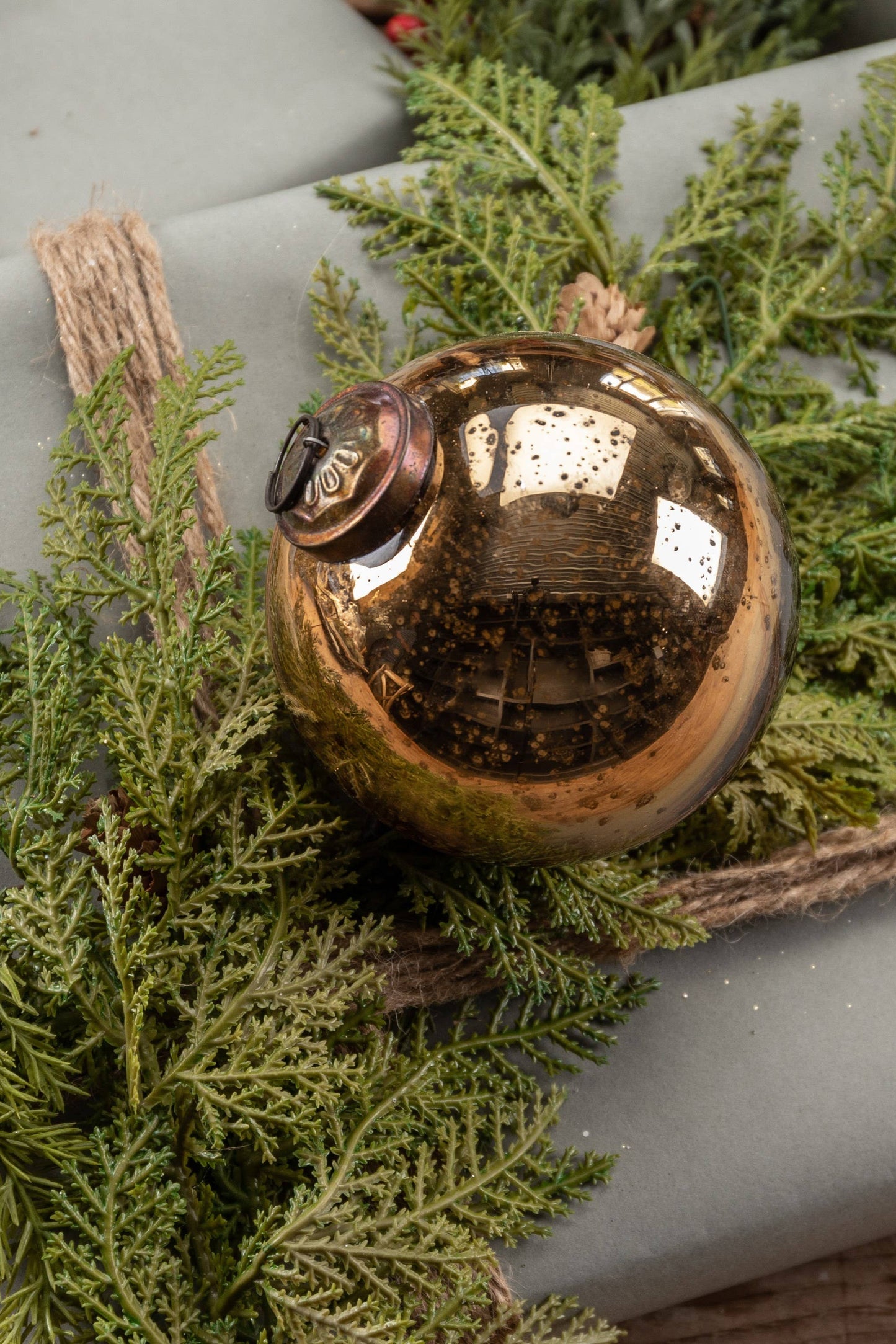 Bronze ornament on a wrapped gift with greenery