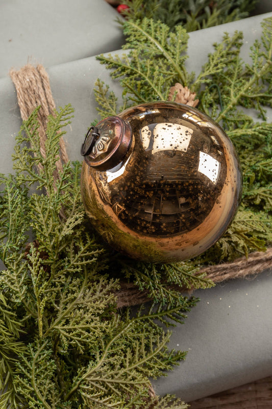 Bronze ornament on a wrapped gift with greenery