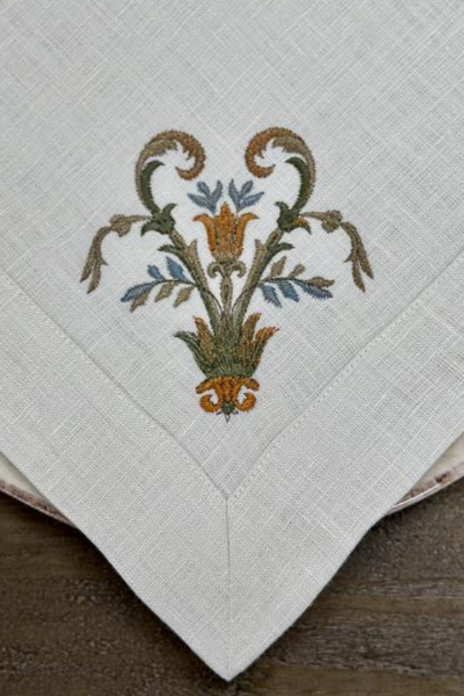 Embroidered napkin with decorative floral pattern on a wooden surface