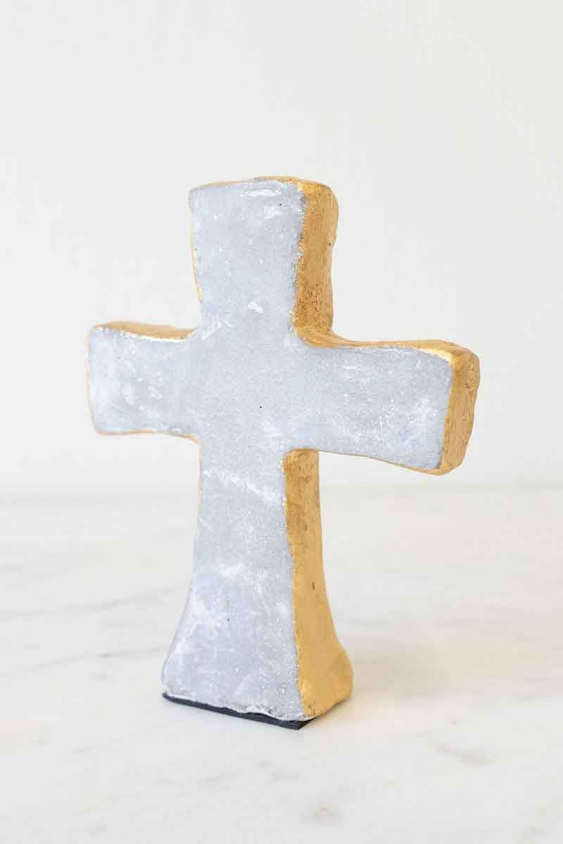 Decorative cross-shaped object with a textured surface on a white background