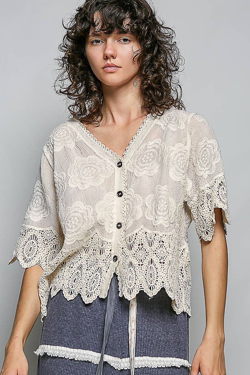 Woman wearing a lace top with a gray background