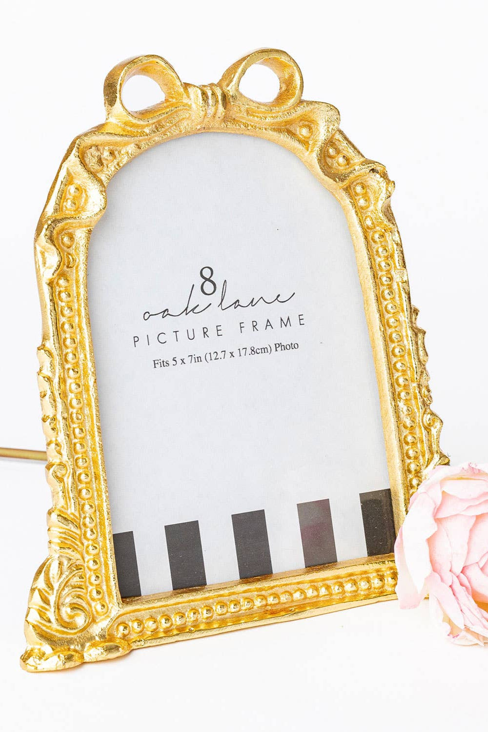 Gold picture frame with decorative bow on a white background