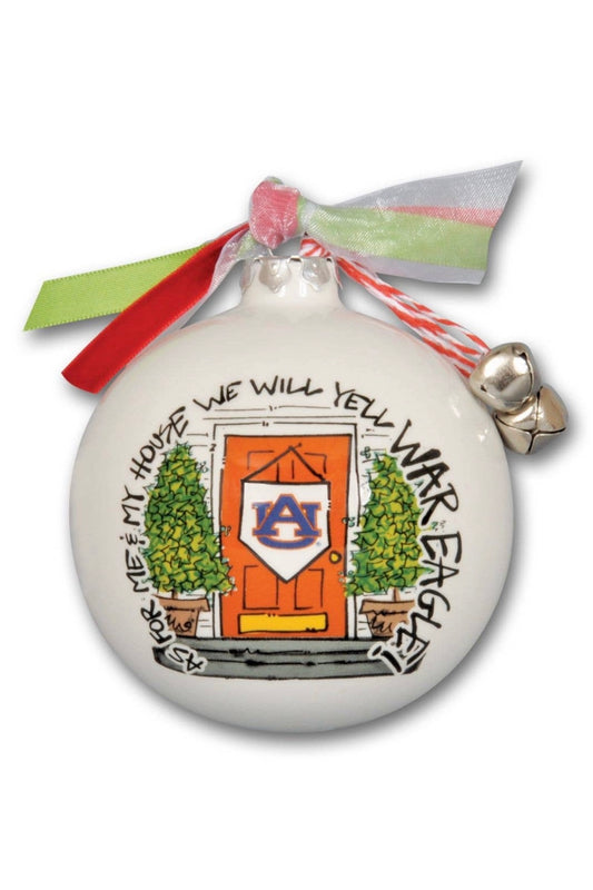 A holiday ornament featuring Auburn University branding, with a festive ribbon at the top, and decorative elements such as holly and a bell.