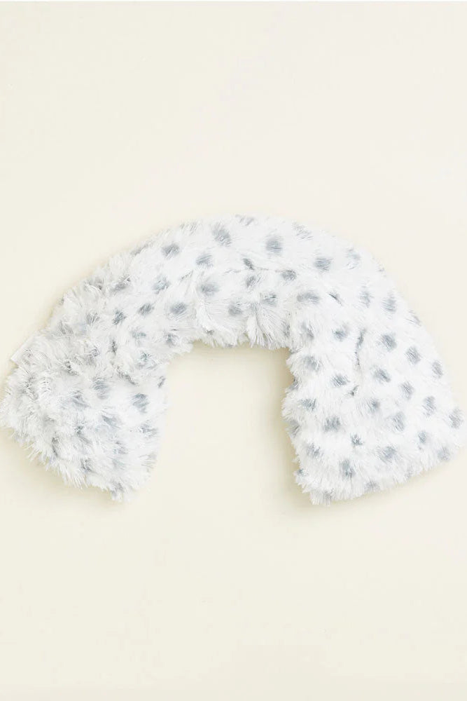 White and gray patterned U-shaped pillow on a beige background