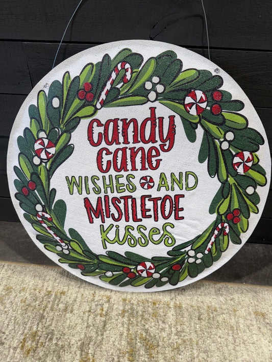 Decorative Christmas sign with candy cane, mistletoe, and holiday text on a white background.