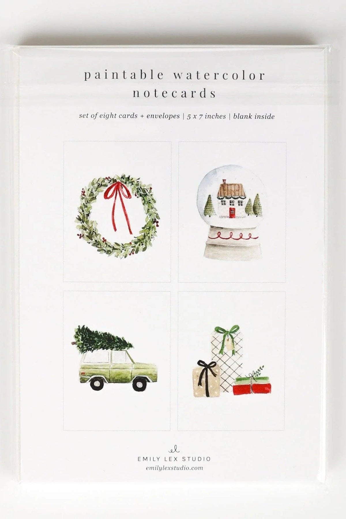 A boxed set of watercolor notecards from Emily Lee Studio, shown in a clear plastic sleeve on a white background. The front card shows four holiday-themed illustrations: a green wreath with a red bow, a snow globe with a small house, a vintage car carrying a Christmas tree, and wrapped gifts.