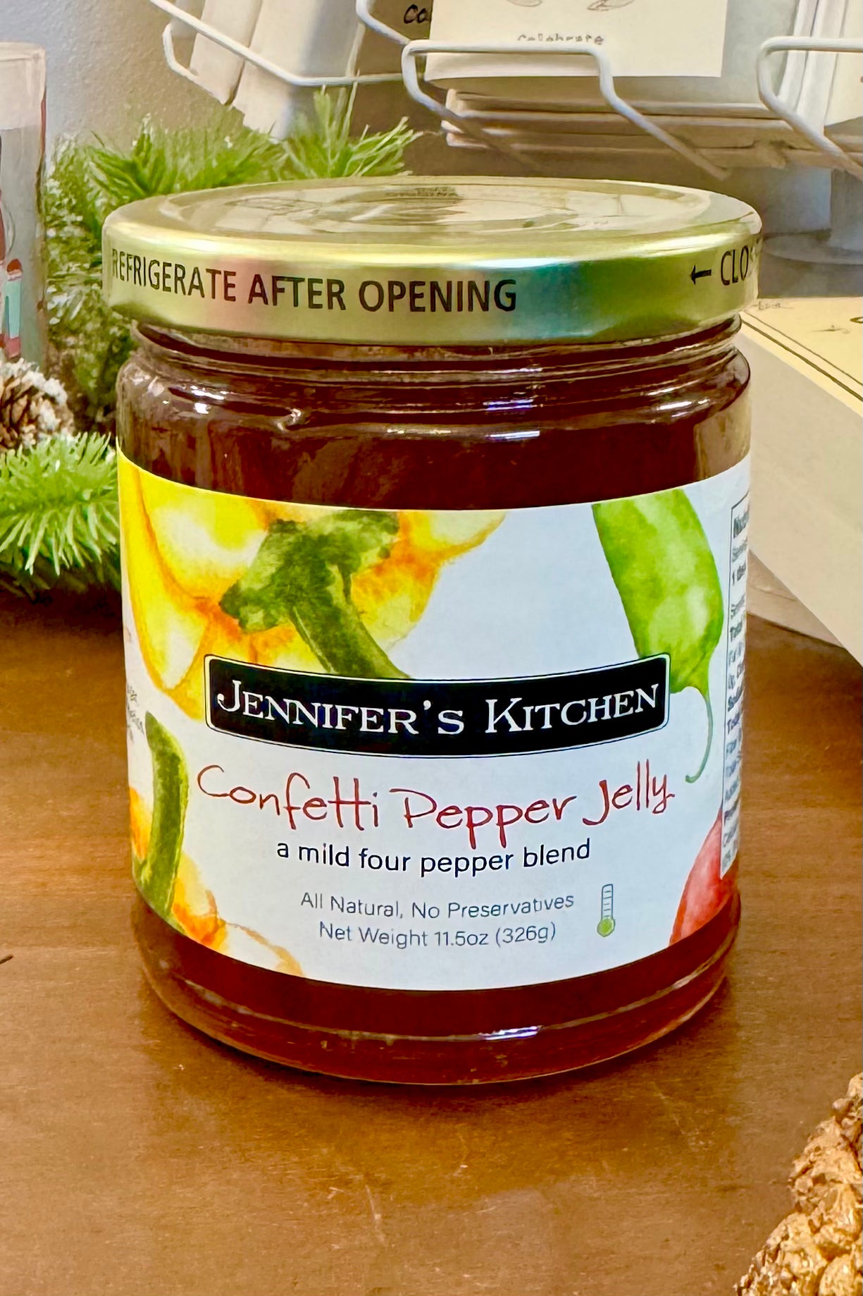 Jar of Jennifer's Kitchen Confetti Pepper Jelly on a wooden surface