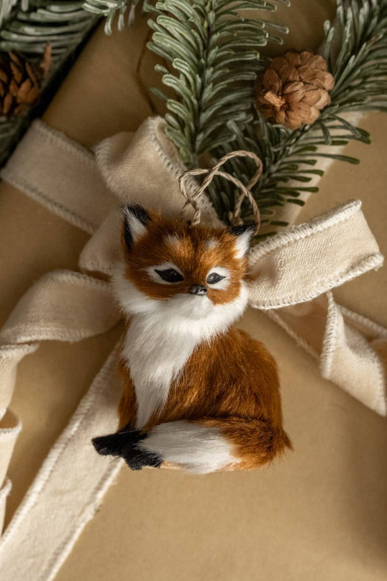 Gift wrapped in brown paper with a decorative ribbon and small fox ornament.