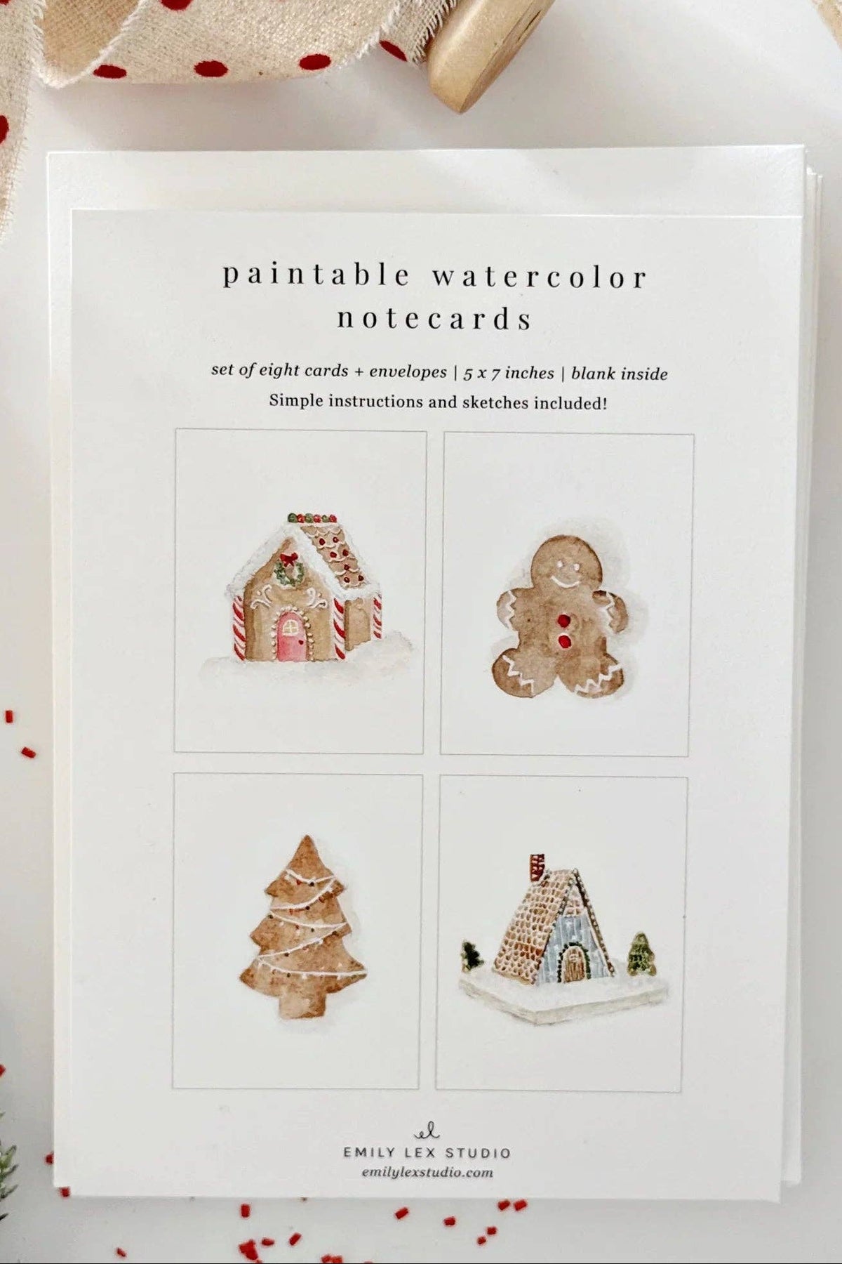 Set of paintable watercolor notecards with Christmas-themed designs on a white surface.