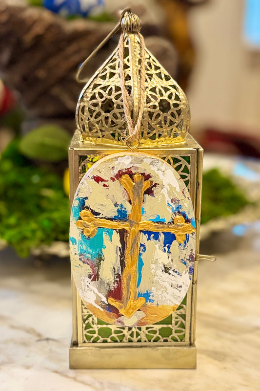 Decorative lantern with cross and anchor design on a marble surface
