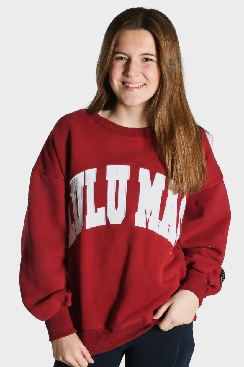Person wearing a red sweatshirt with 'Lulu Mac ' text on a white background