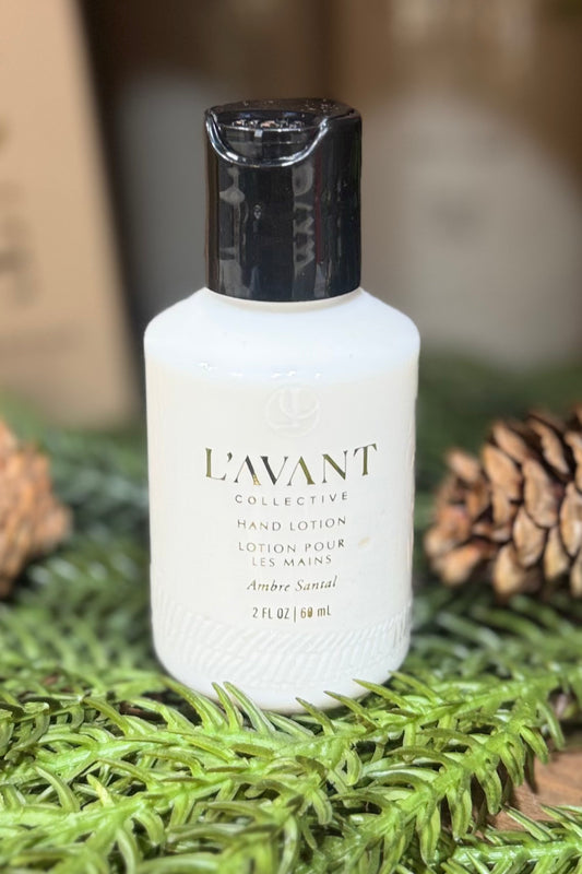 L'AVANT hand lotion bottle on a green surface with pine cones