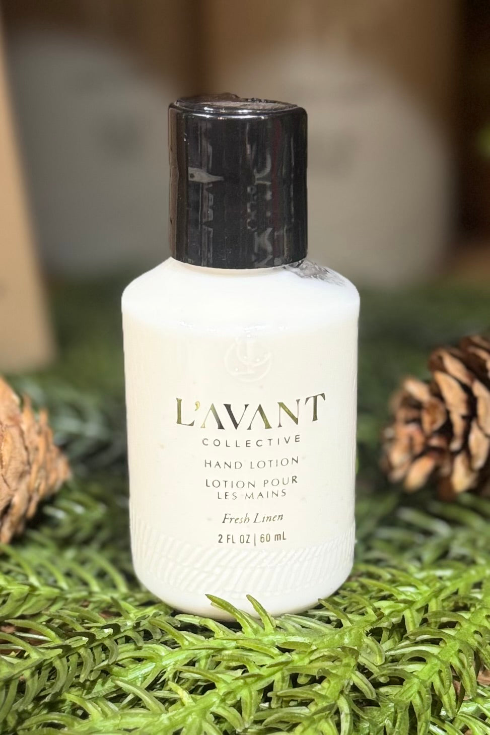 L'AVANT hand lotion bottle on a natural background with pine cones and greenery
