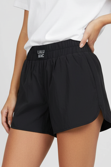 Person wearing black shorts and a white t-shirt on a plain background