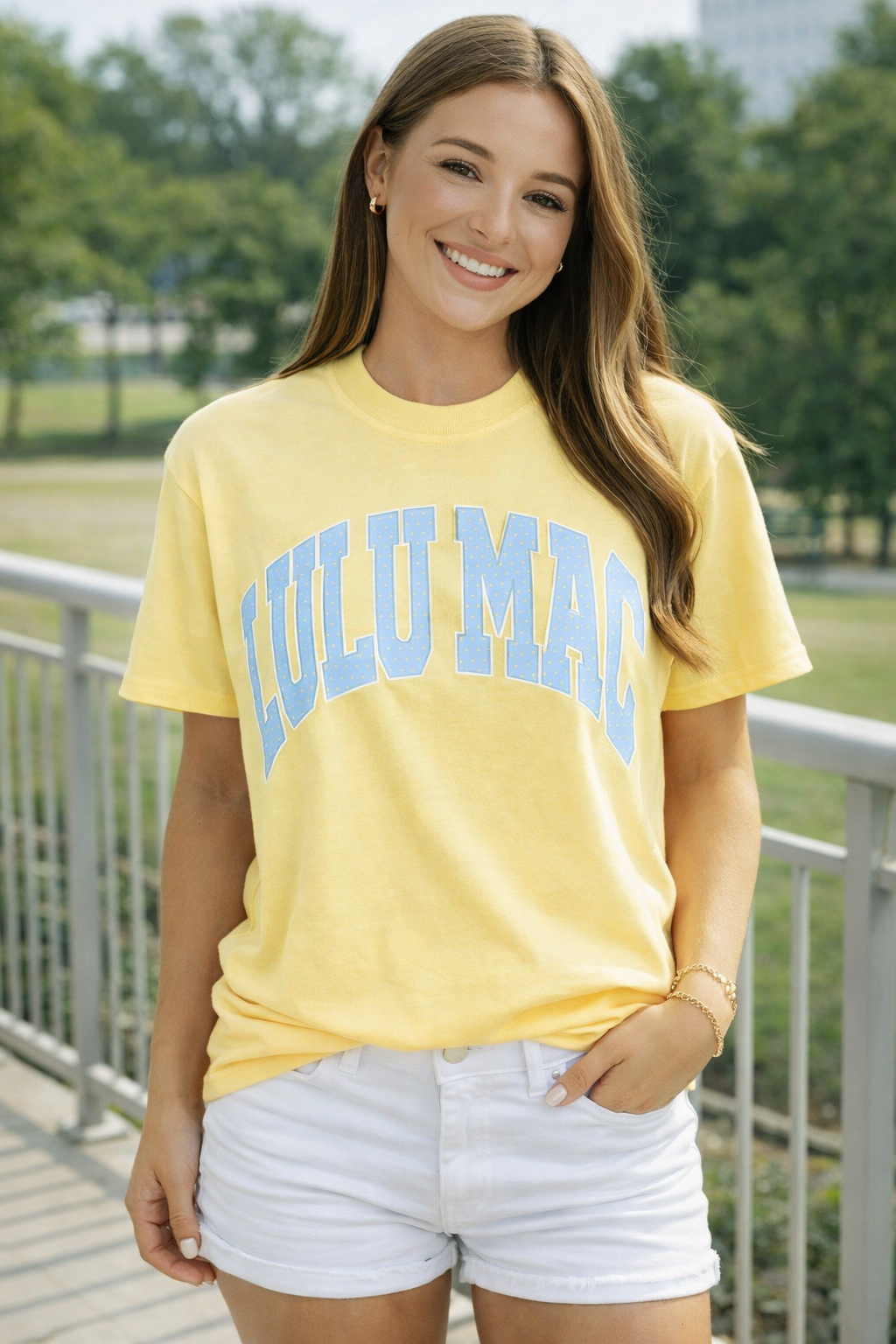 Woman wearing a yellow 'LULU MAc t-shirt outdoors