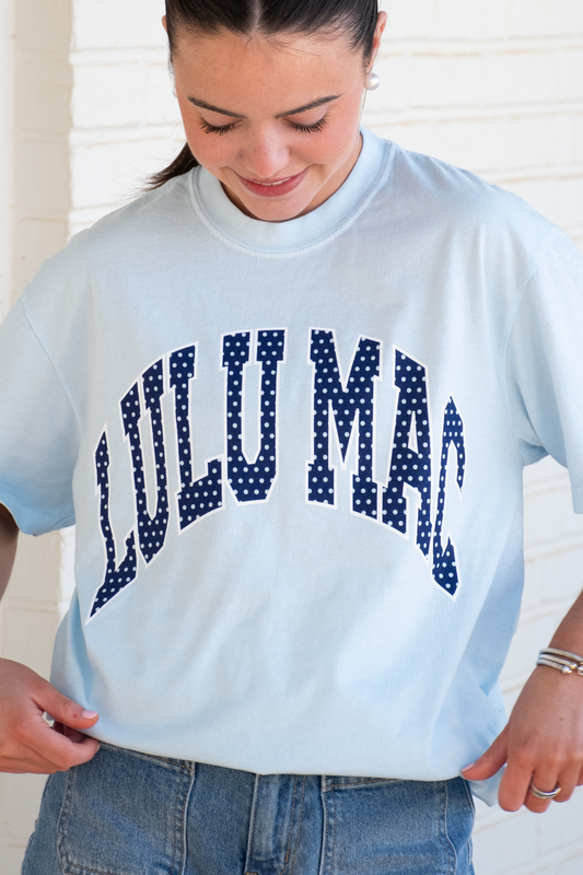Person wearing a light blue t-shirt with 'LULUMAc printed in dark blue letters.