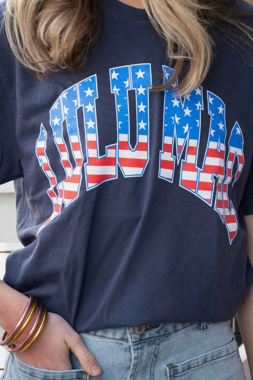 Navy blue t-shirt with American flag design on a person wearing jeans.