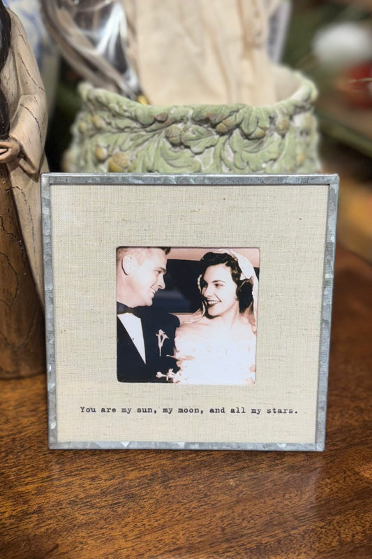 Framed photo of a couple with a romantic quote on a wooden surface