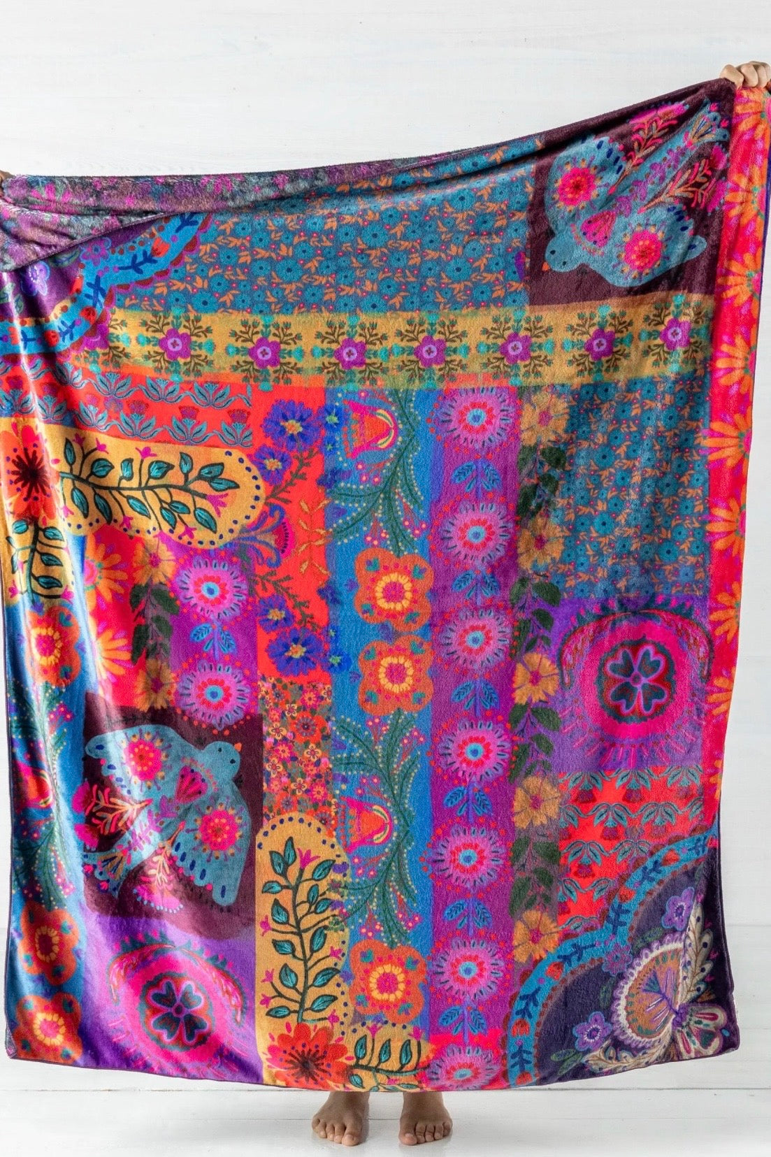 Colorful patterned fabric draped over a person on a white background