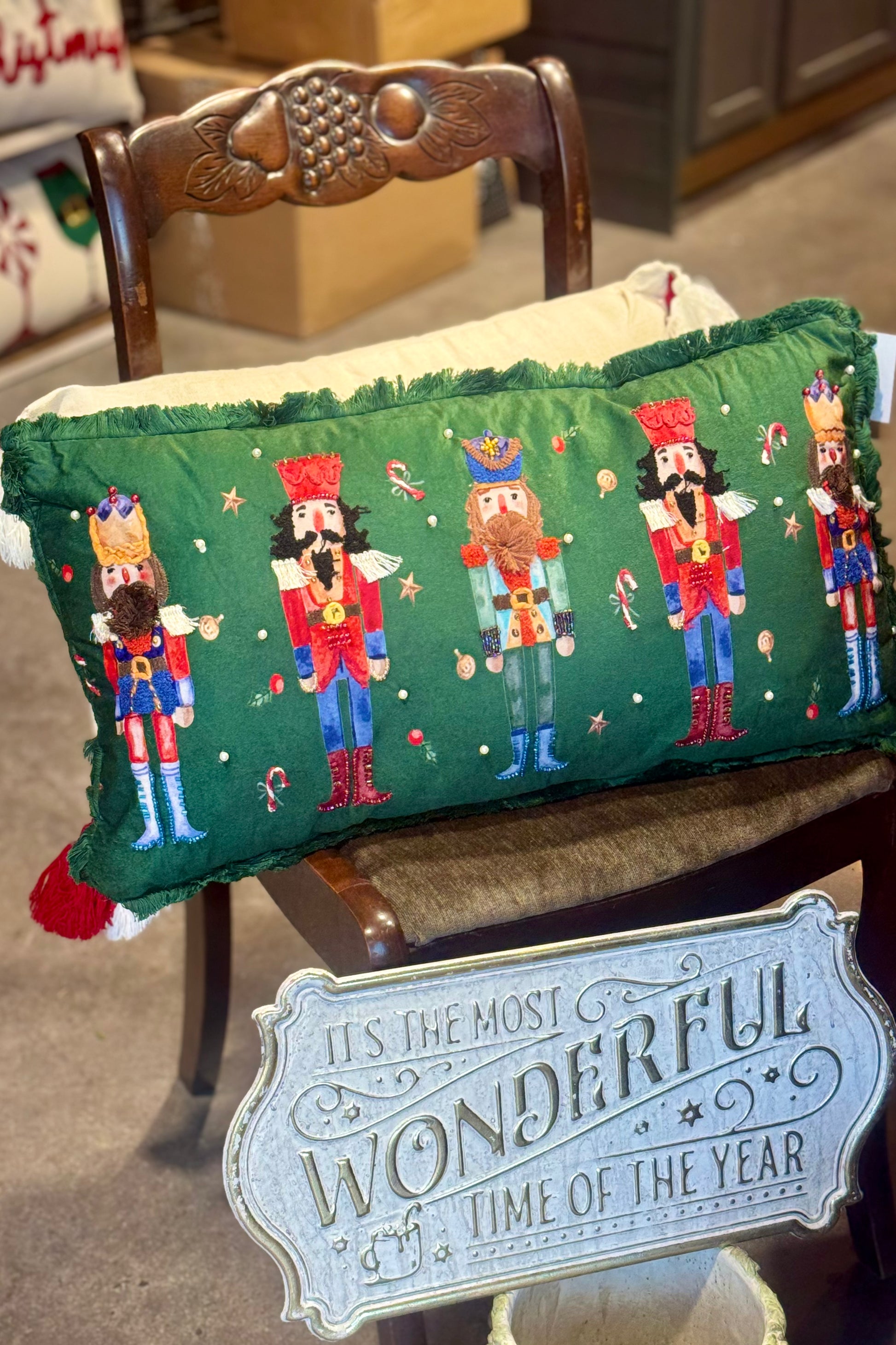 Decorative pillow with Nutcracker design on a chair with a 'Wonderful Time of Year' sign.
