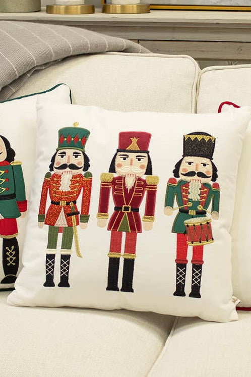 Decorative pillows with nutcracker designs on a beige sofa.