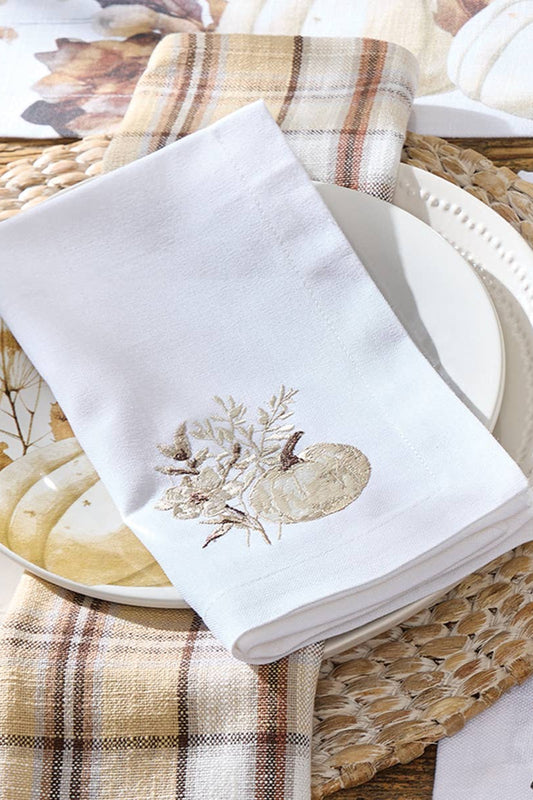 Napkin with autumnal design on a plate with a woven placemat