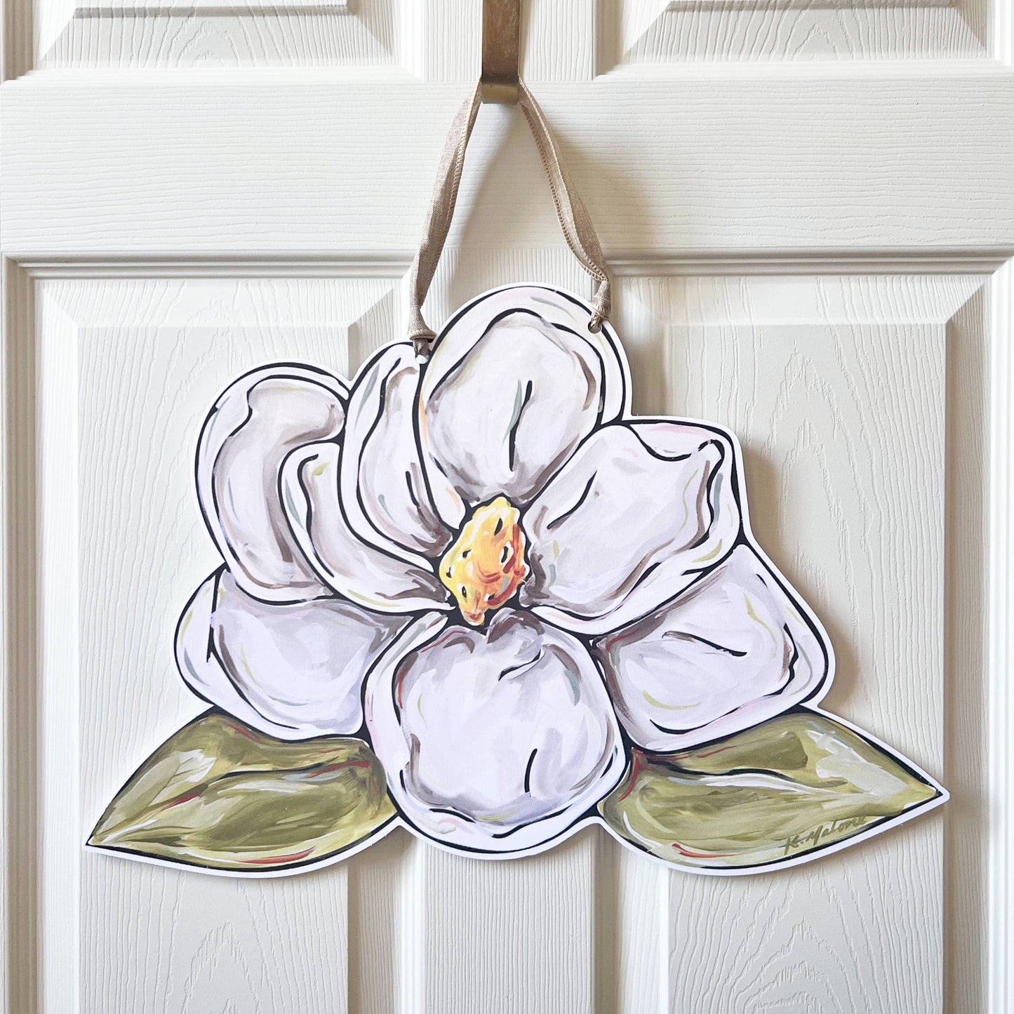 Decorative white flower-shaped ornament hanging on a white door.