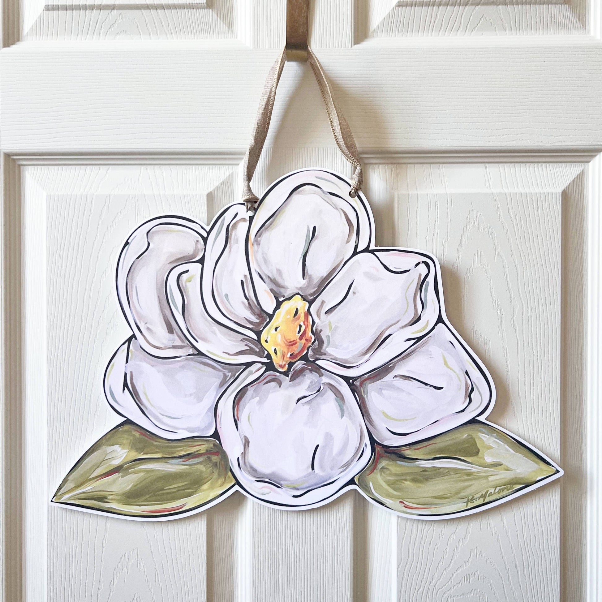Decorative white flower-shaped ornament hanging on a white door.