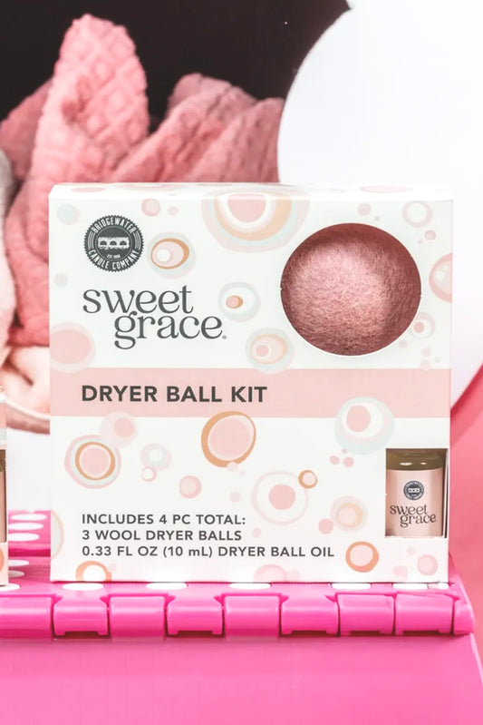 Sweet Grace dryer ball kit with dryer balls and oil on a pink background