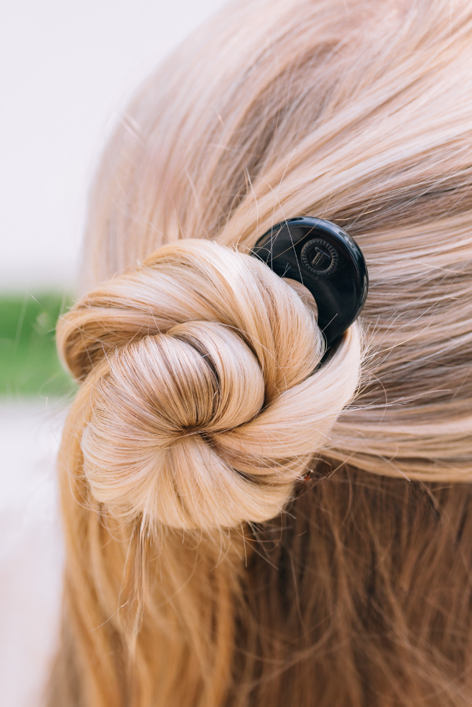 Close-up of a braided hairstyle with a Teleties French hair pin a blurred background