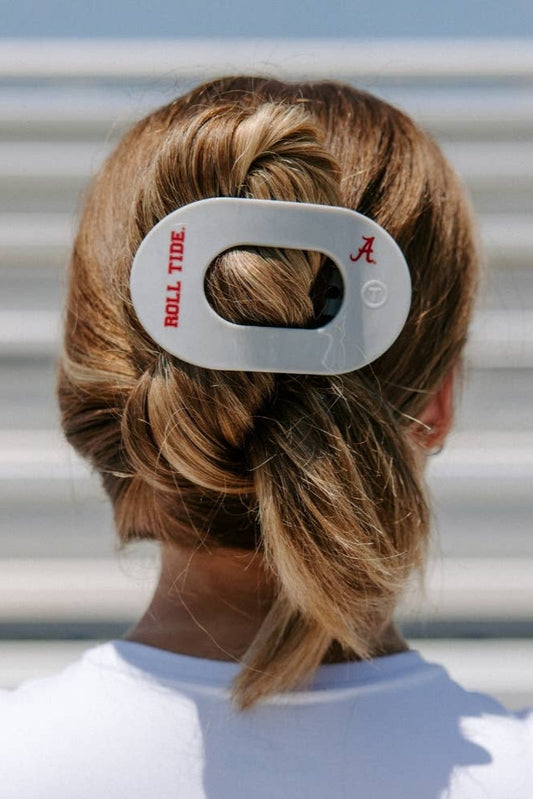 Person with braided hair wearing a hair tie with 'Roll Tide' and 'A' branding.