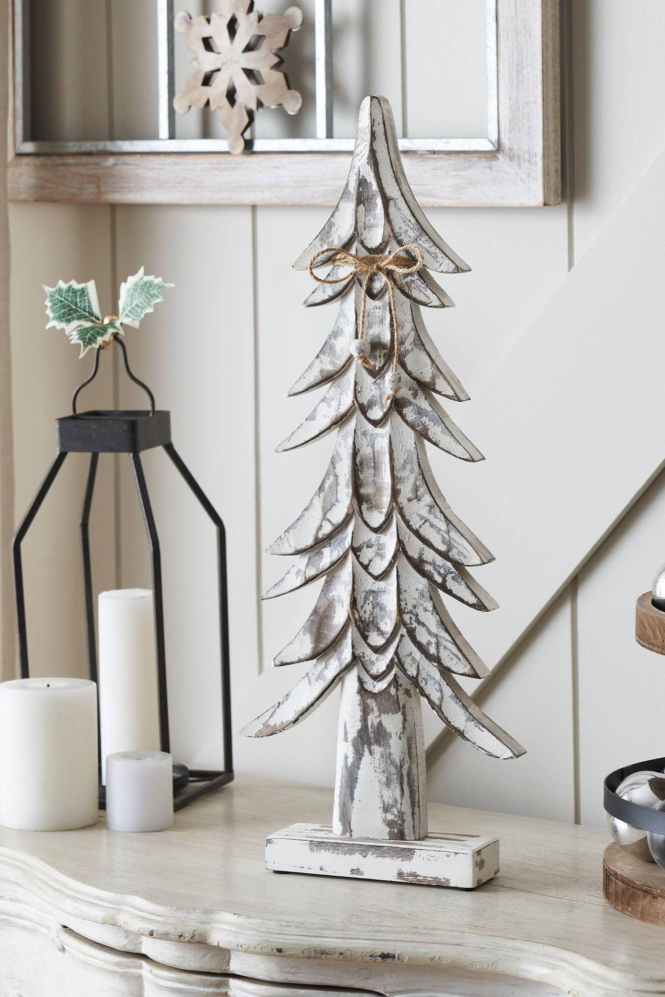 Decorative Christmas tree on a table with candles and ornaments in a home setting