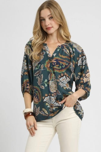 Woman wearing a patterned blouse with a plain background
