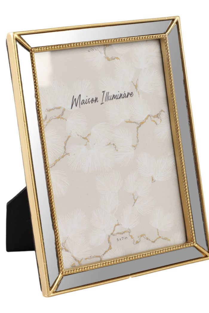 Gold-framed photo with marble background and 'Maison illuminare' branding on a white background