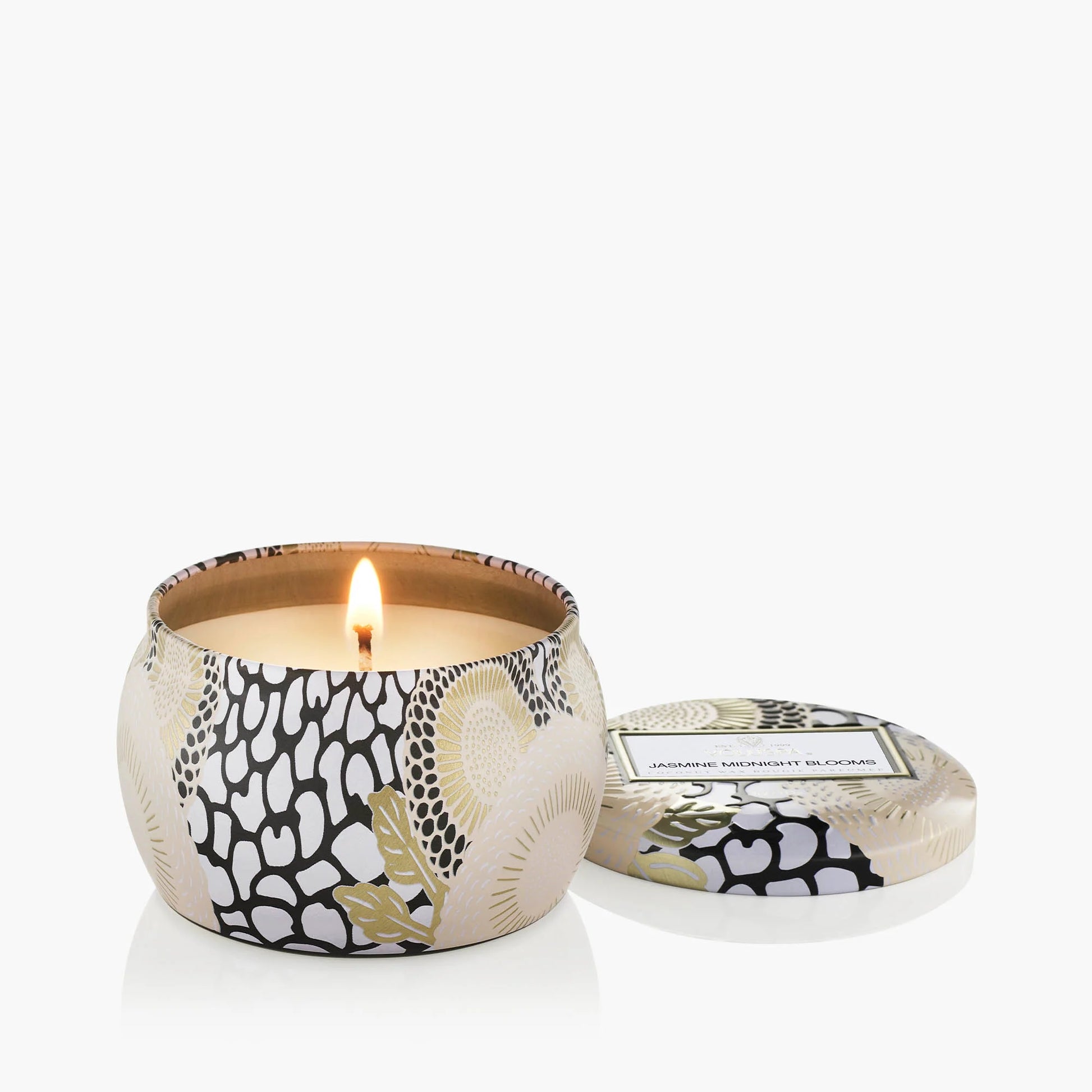 Patterned candle with a lit wick on a white background Voluspa Jasmine Midnight Blooms 4 oz Mini Tin Candle
