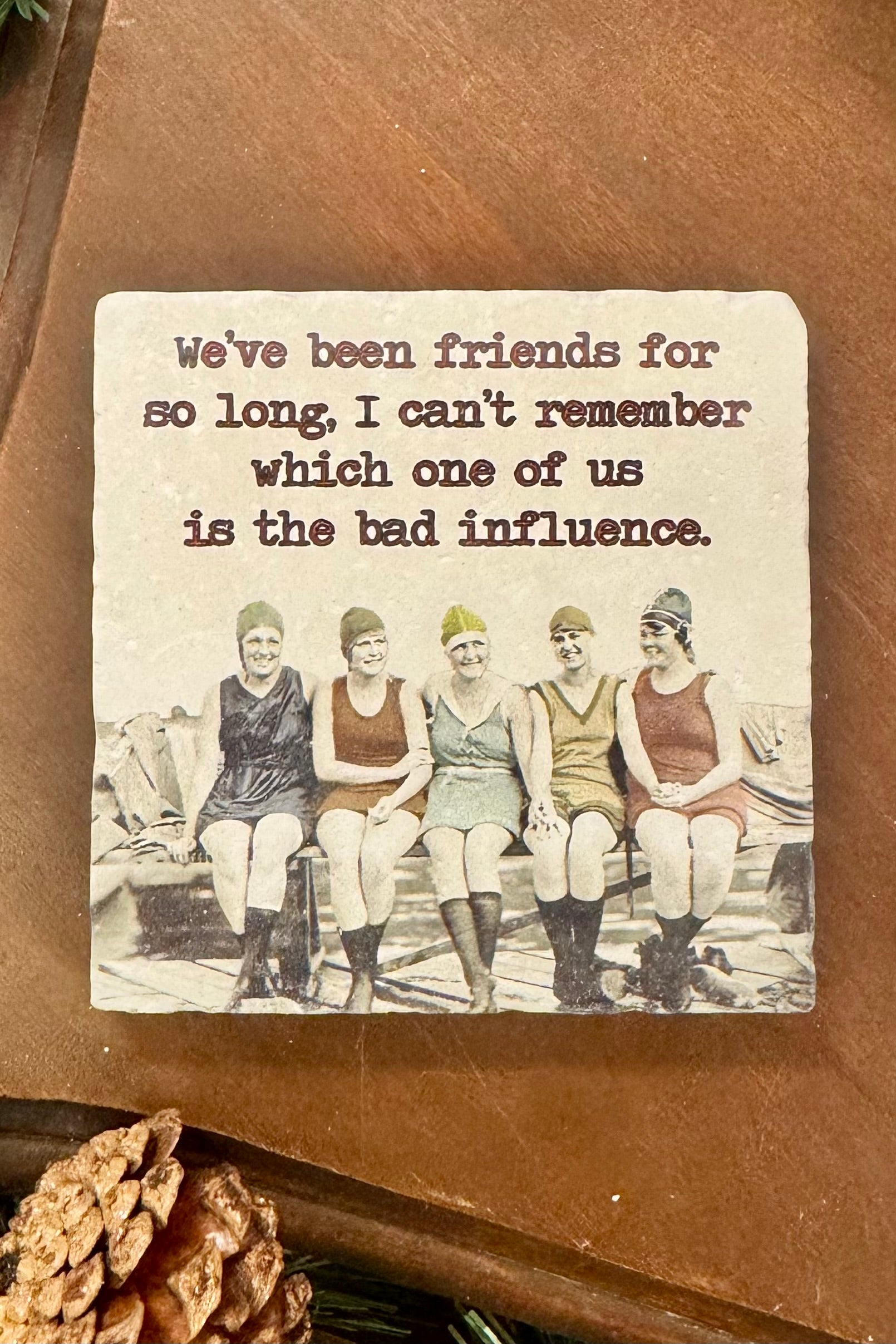 Vintage-style coaster with a humorous quote and black and white photo of women in swimsuits.