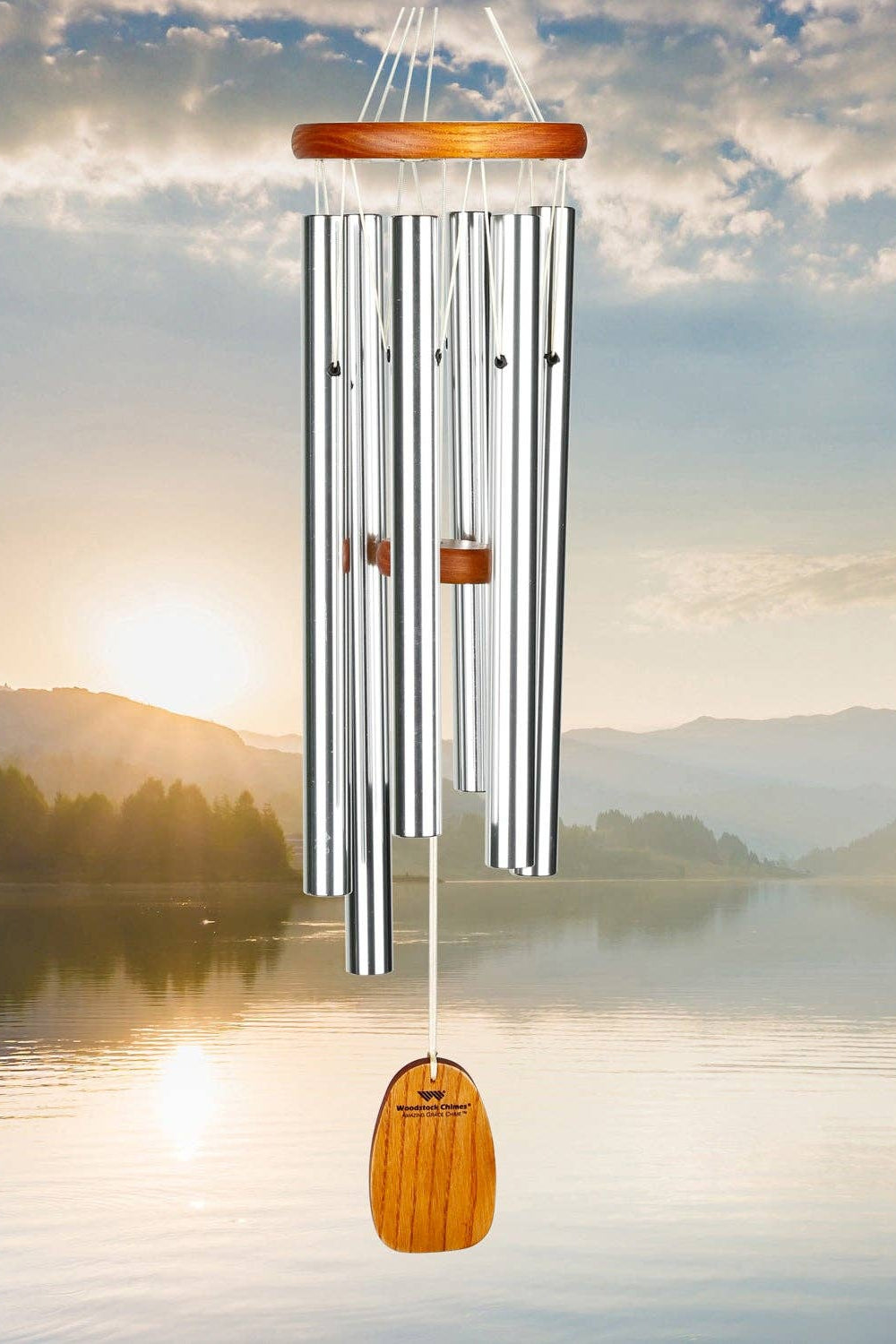 Wind chime with wooden accents against a scenic backdrop of a lake and mountains.