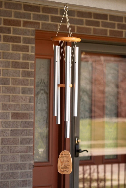 Wind chime hanging on a brick wall with a door in the background