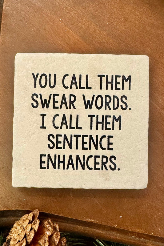 Square stone coaster with humorous text on a wooden surface