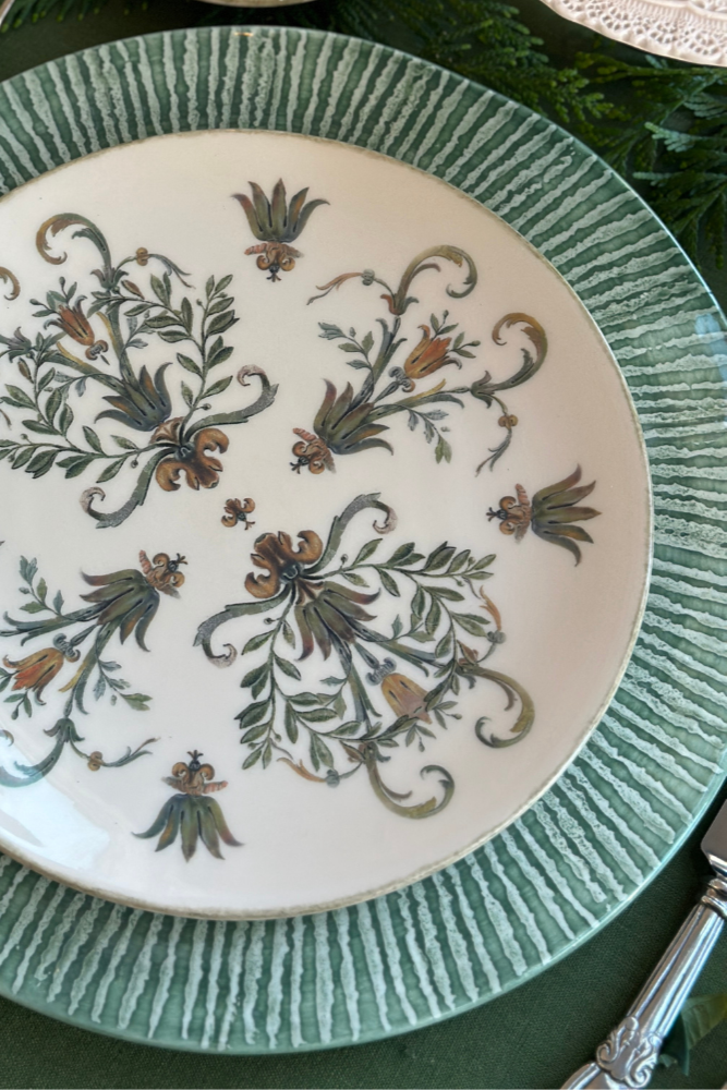 Decorative plate with floral patterns on a green tablecloth