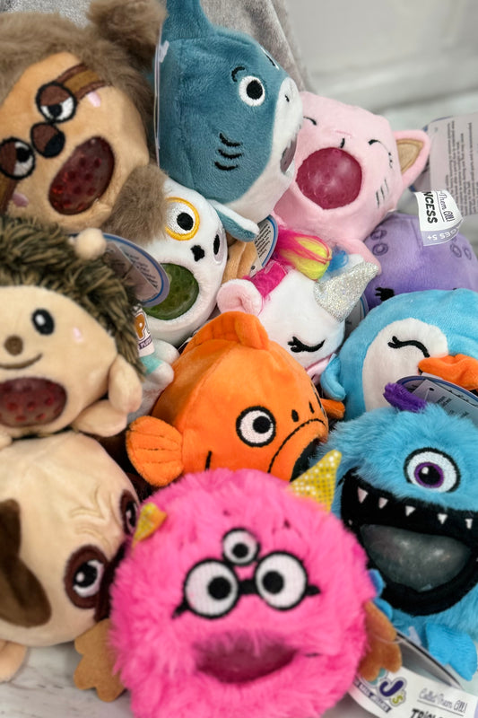 A collection of colorful plush toys designed to look like animals with simplified, stylized features, many with a gel bead ball inside.